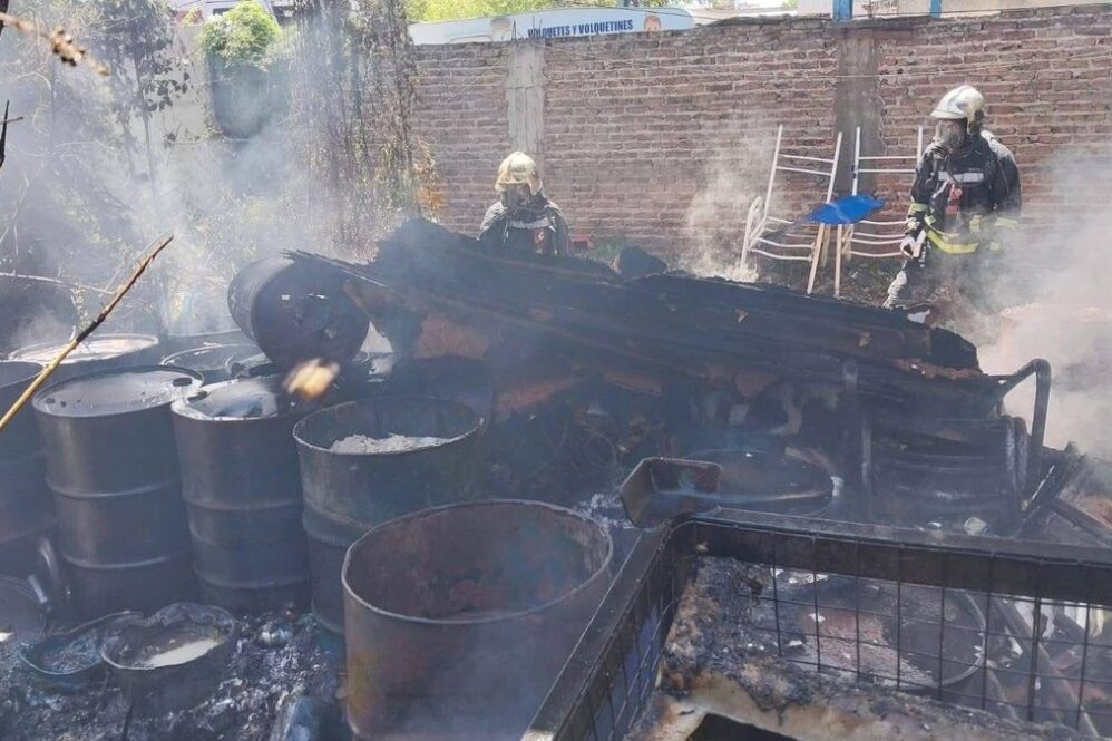 Bomberos Voluntarios de Lomas de Zamora trabajan en el interior del galpón incendiado este lunes en la calle Garona al 1600.