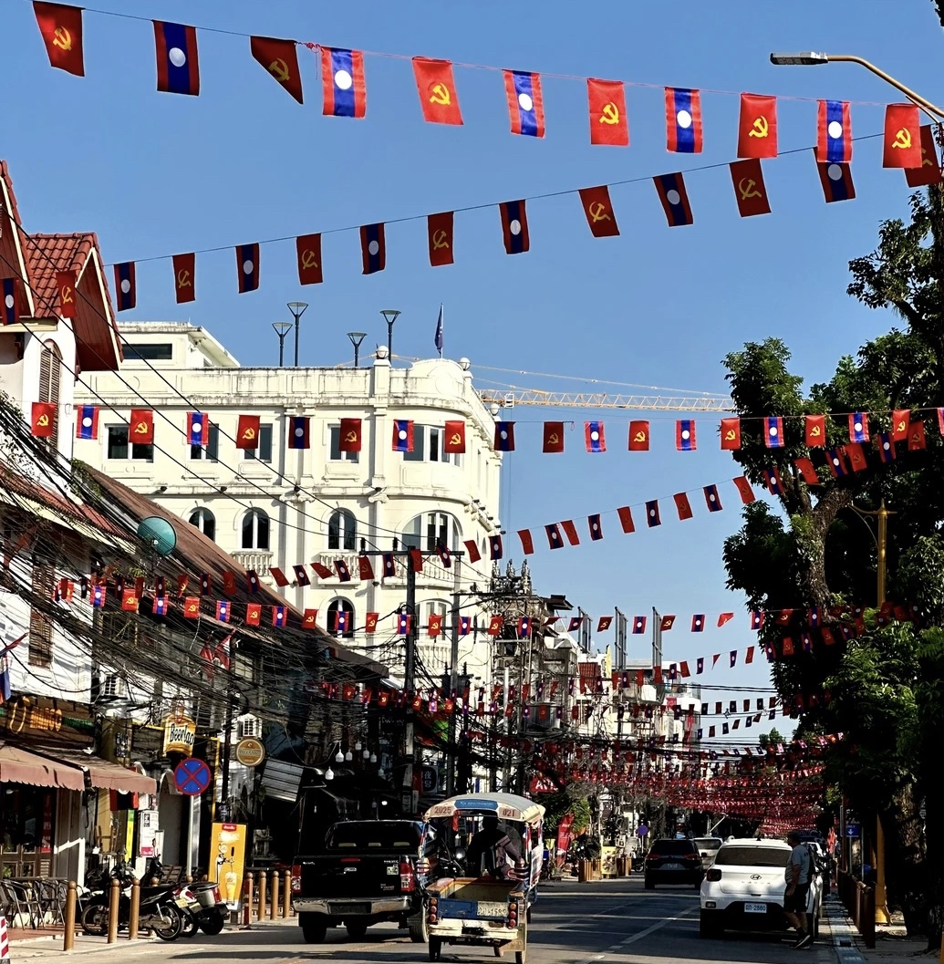 La farsa española en Laos: espías y mentiras 3 Banderas del Partido Popular Revolucionario de Laos en una calle de Ventián.